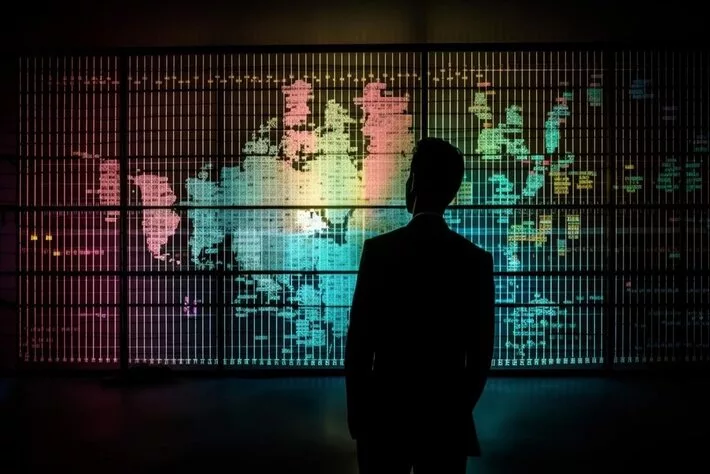 young businessman standing front glowing world map